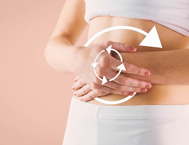 Woman holding her stomach with circular digestive health icons, representing colon hydrotherapy and detox benefits.